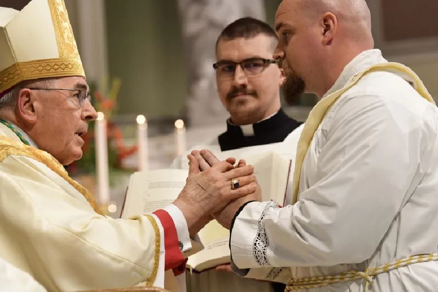 Das Photo zeigt den Weihekandidaten, der vor dem Bischof kniet und ihm 'in die Hand' Gehorsam verspricht