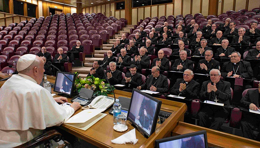 Der Papst spricht im Konferenzsaal zu den Bischöfen, die Beifall klatschen.