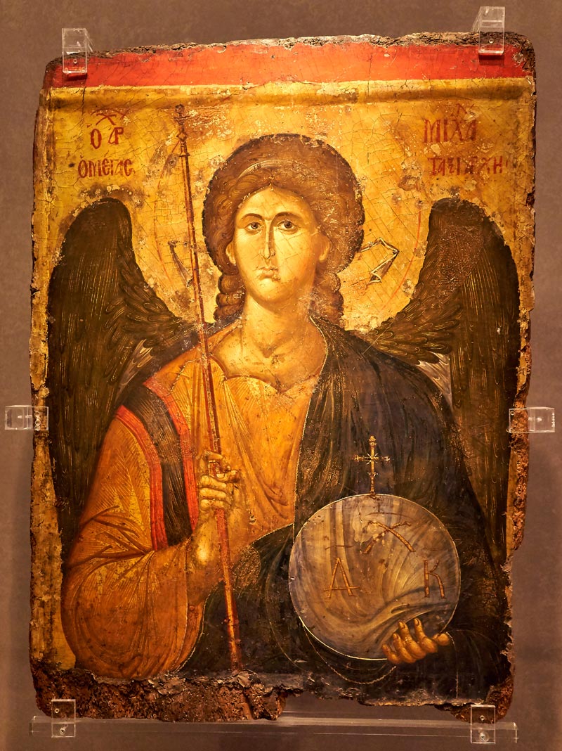 Die Ikone im byzantinischen Stil zeigt den Erzengel im Brustbild in einer christusähnlichen Haltung mit einem Botenstab/Szepter in der rechten Hand und einer durchscheinenden Globus-Sphäre in der Linken.