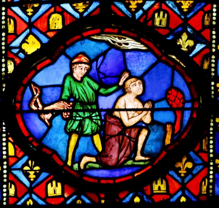 Das Glasfenster in starken Rot- und Blautönen zeigt den knienden Theophilus, der von dem hinter ihm stehenden Vollstrecker mit einer Geißel gezüchtigt wird. 