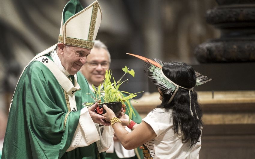 Eine Dame im Indianerkostüm überreicht dem Papst zur Opferung eine Schale mit heidnischer Symbolik